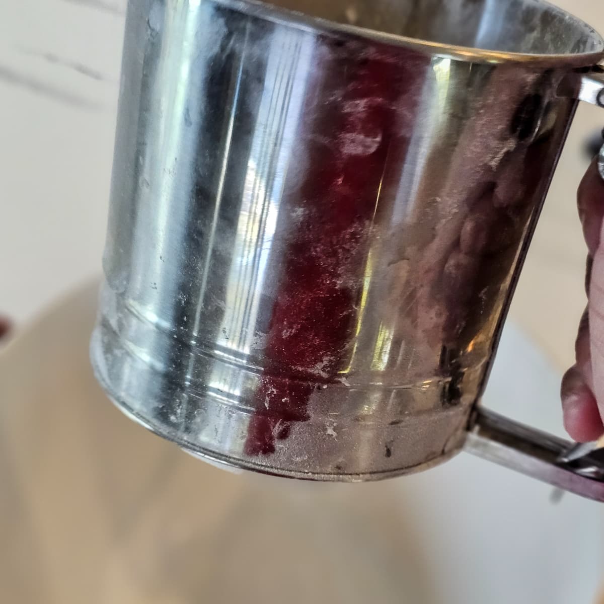 Sifting flour into a bowl.