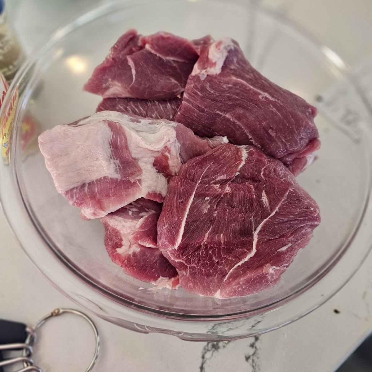 Large chucks of pork shoulder in a bowl.