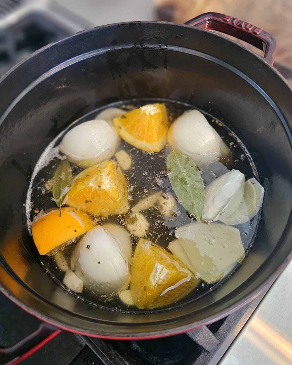 Onions and orange cooking in melted lard.