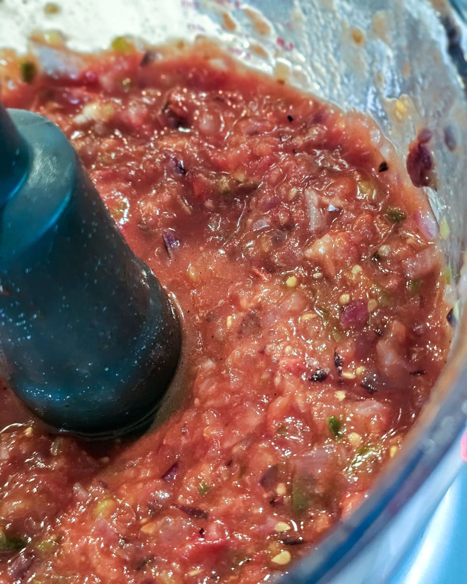 Blending smoked salsa in a food processor.