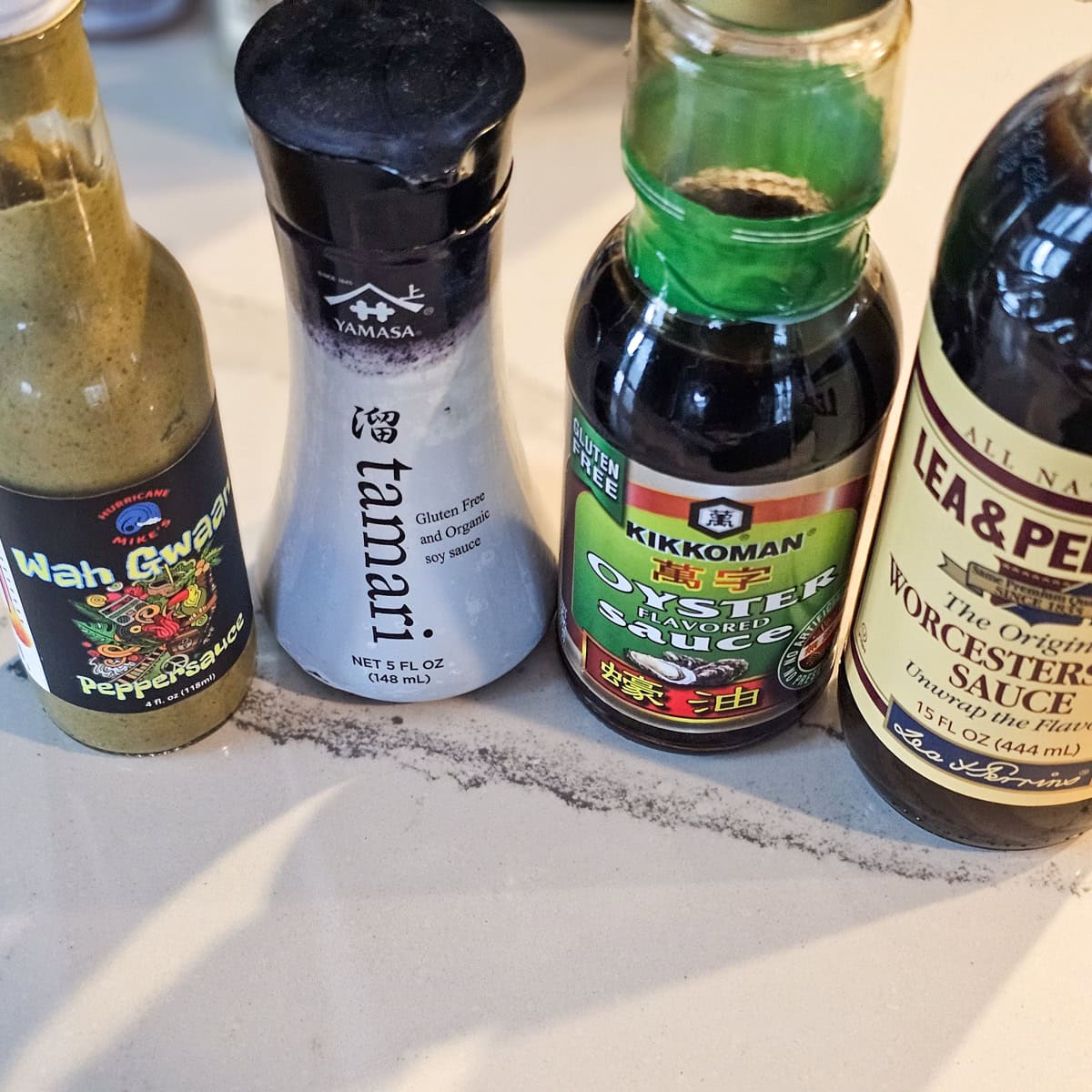 Bottles of hot sauce, soy sauce, oyster sauce and Worcestershire sauce.