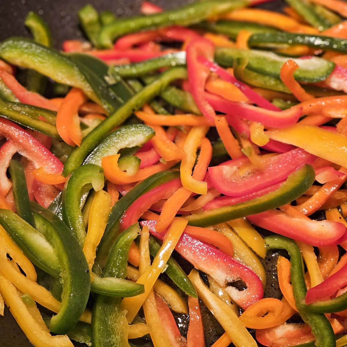 Assorted colored strips of bell pepper in a bowl.