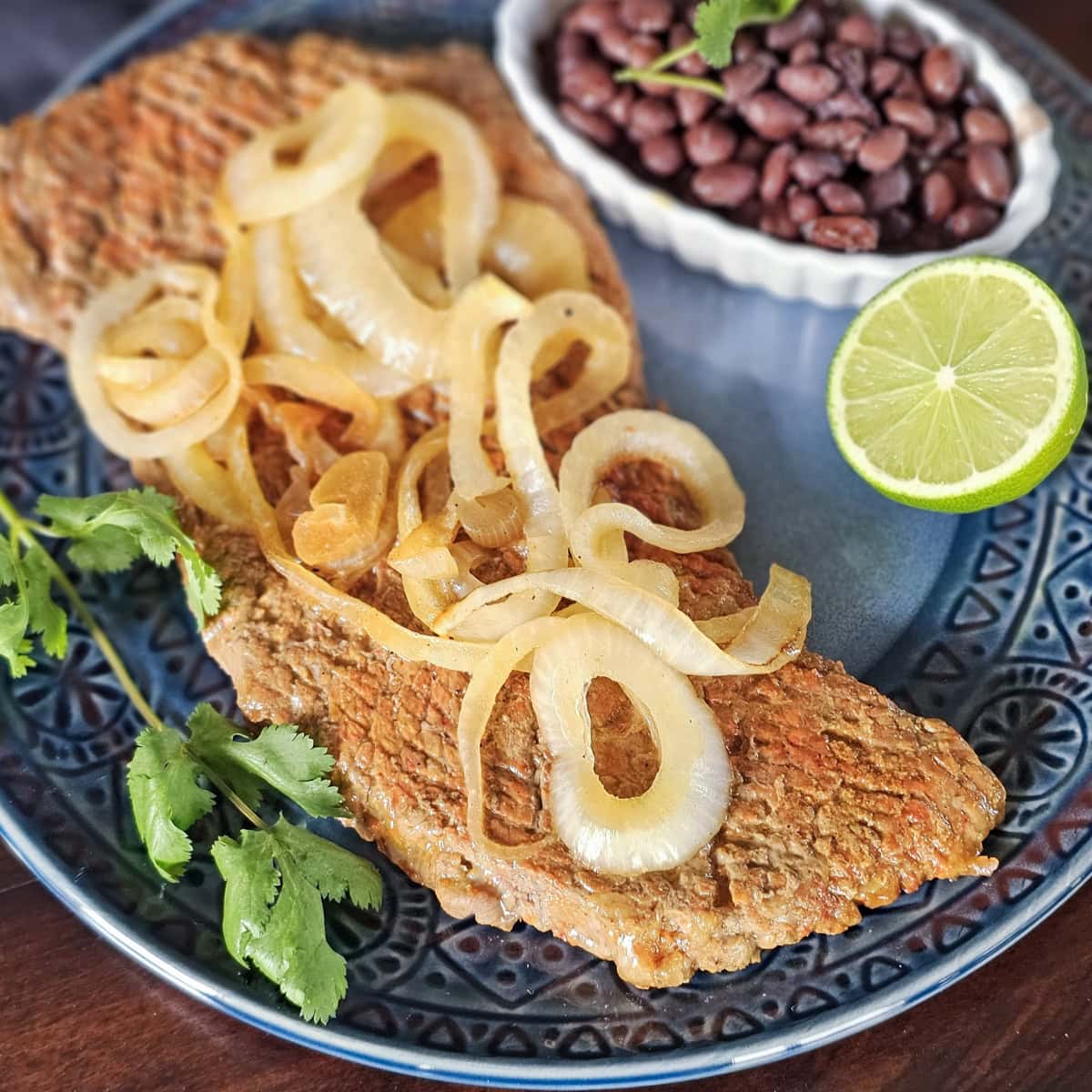 Plate of homemade bistec palomilla: steak and onions.