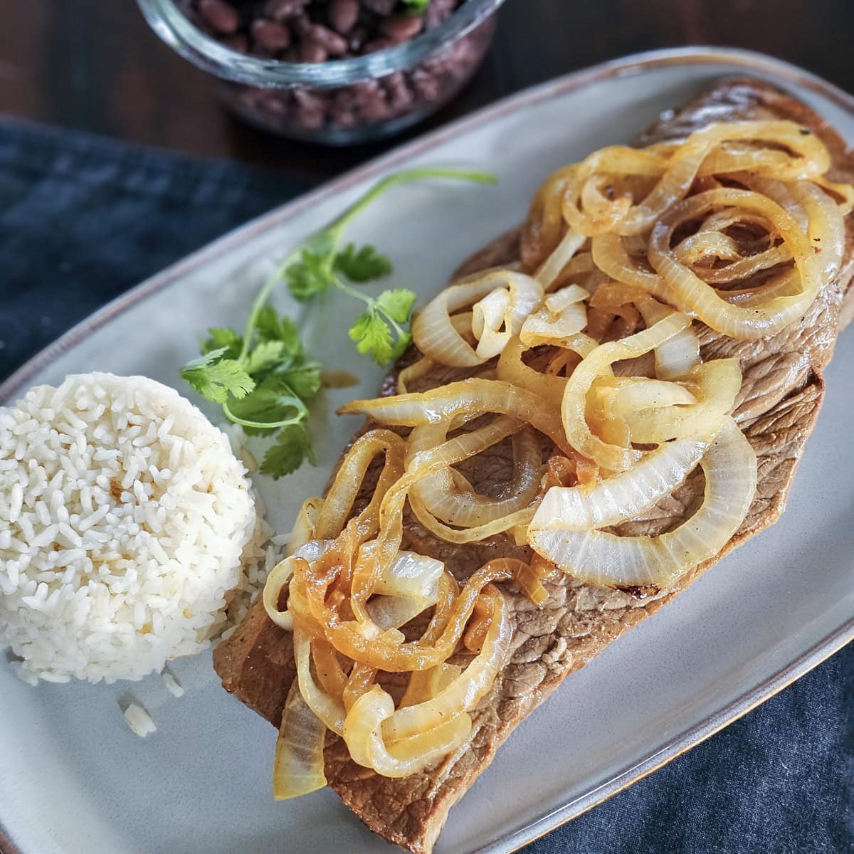 Cuban style steak and onions served with rice and black beans.