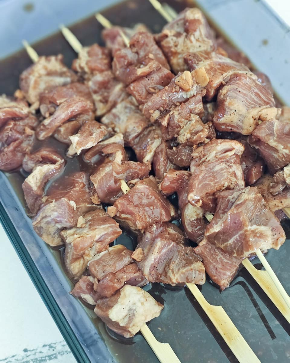 Marinated pork on wooden skewers.