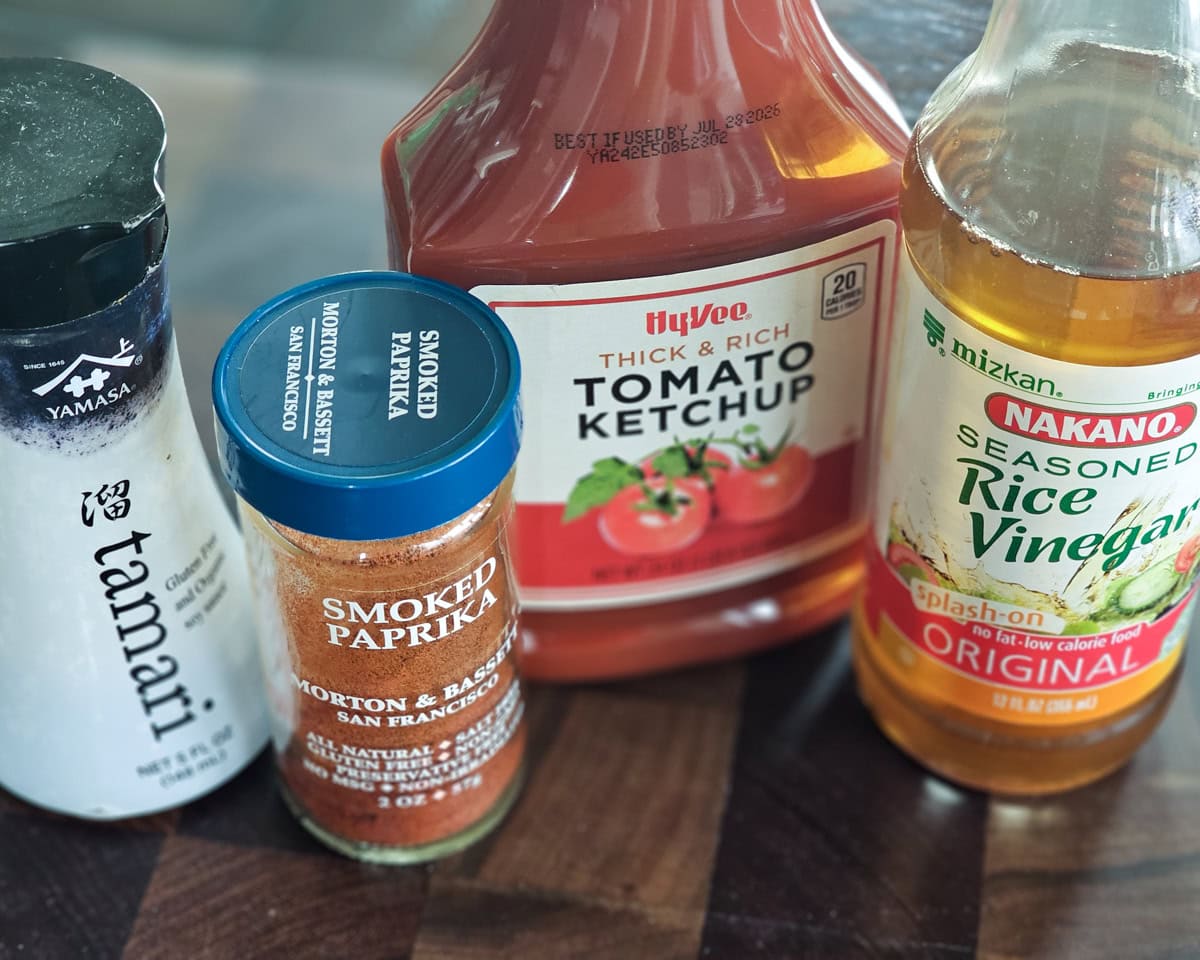 Tamari sauce, ketchup, rice wine vinegar, and smoked paprika on a table.