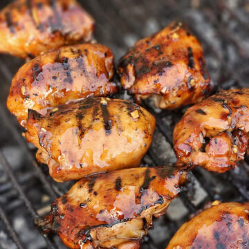 Charcoal grilled Hawaiian Huli Huli chicken cooking on a BBQ grill.