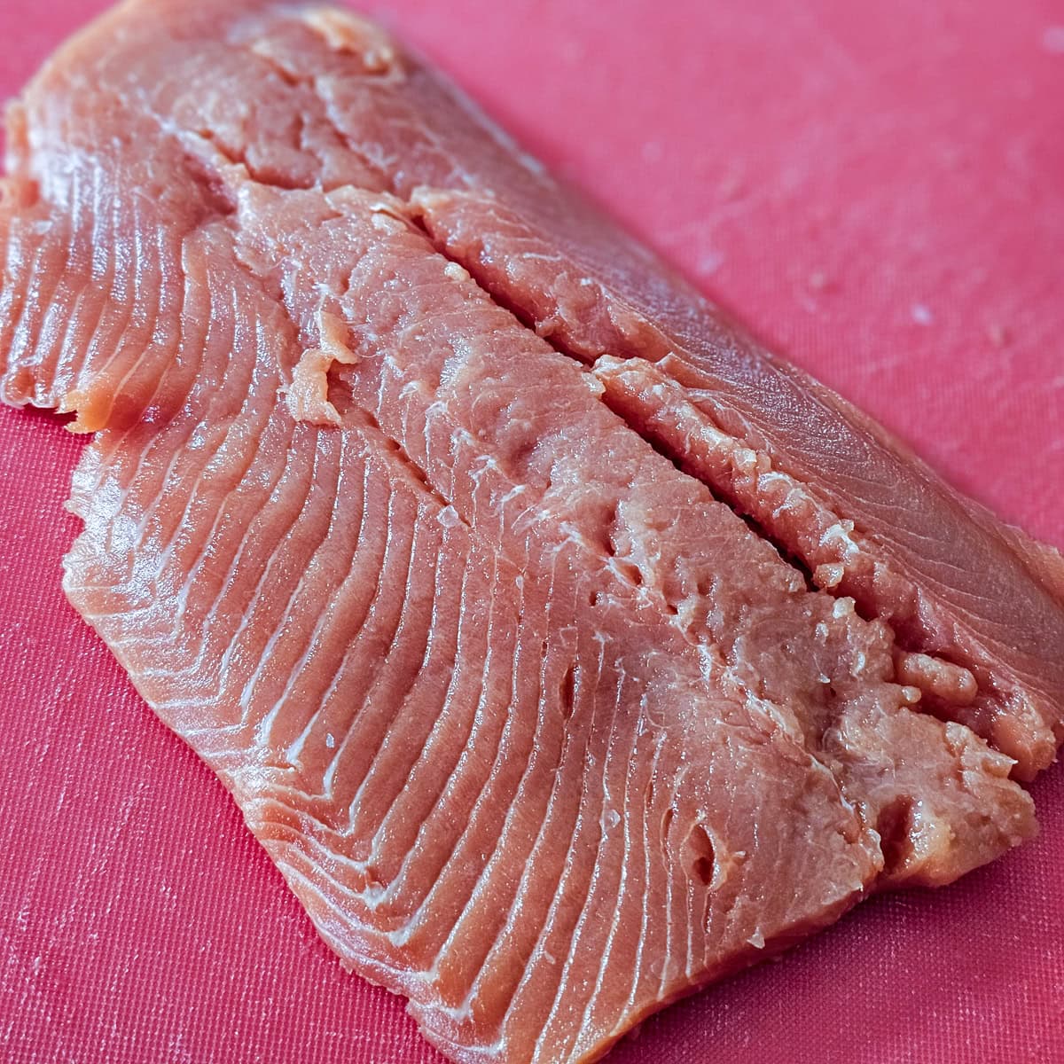 Filet of sockeye salmon on a cutting board.