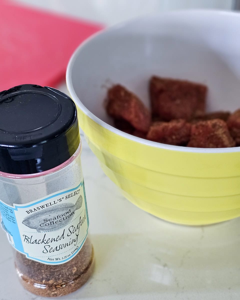 Bowl of salmon bites seasoned with blackening seasoning.