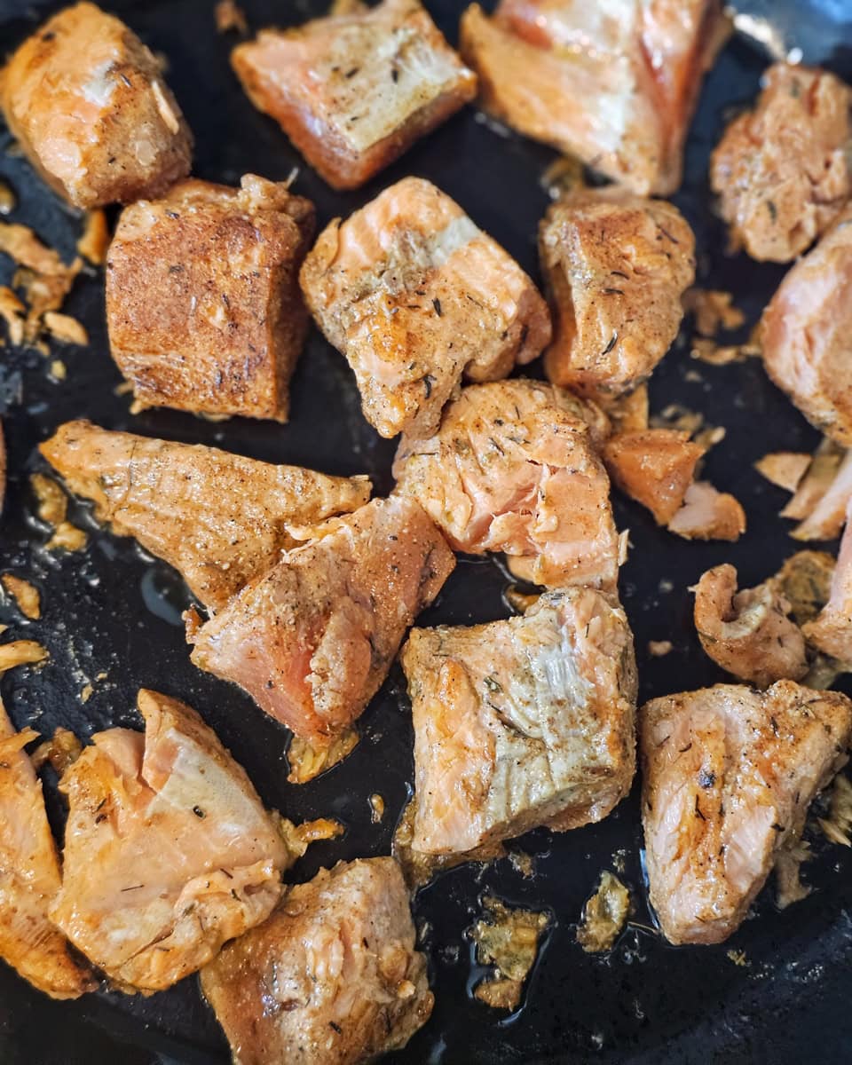 Cajun salmon bites cooking on a Blackstone.