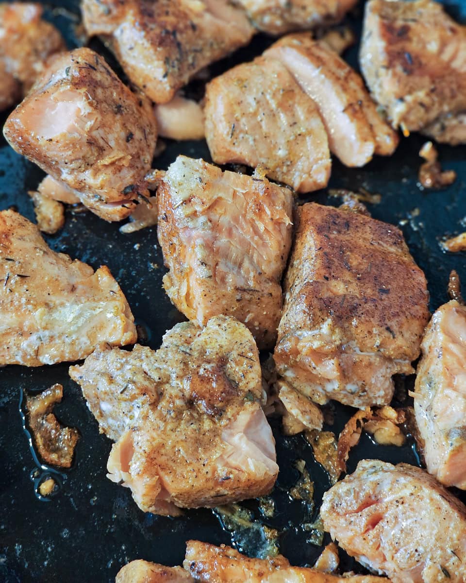 Cooking blackened Cajun salmon bites.