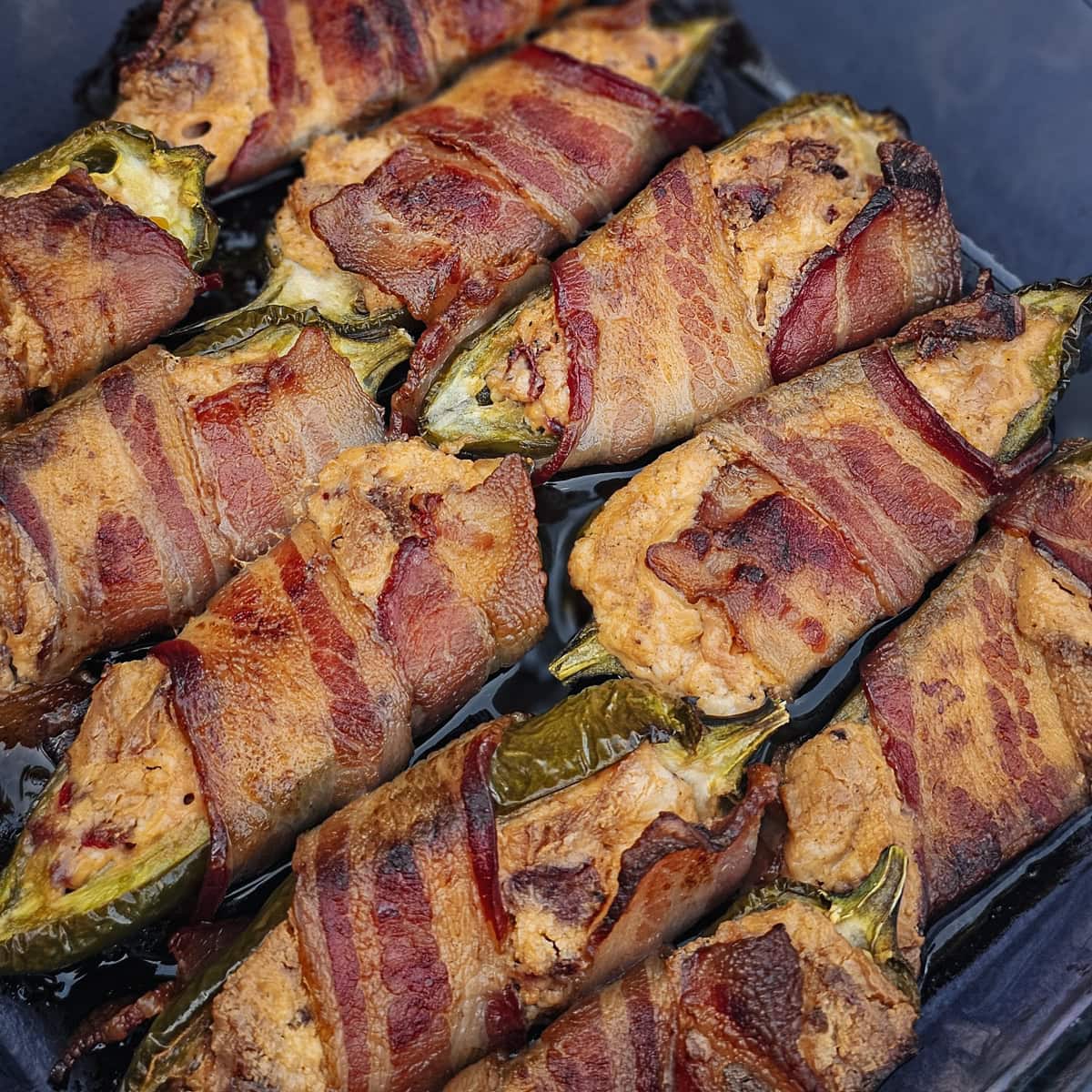 Hot link sausage stuffed jalapenos, wrapped in bacon.