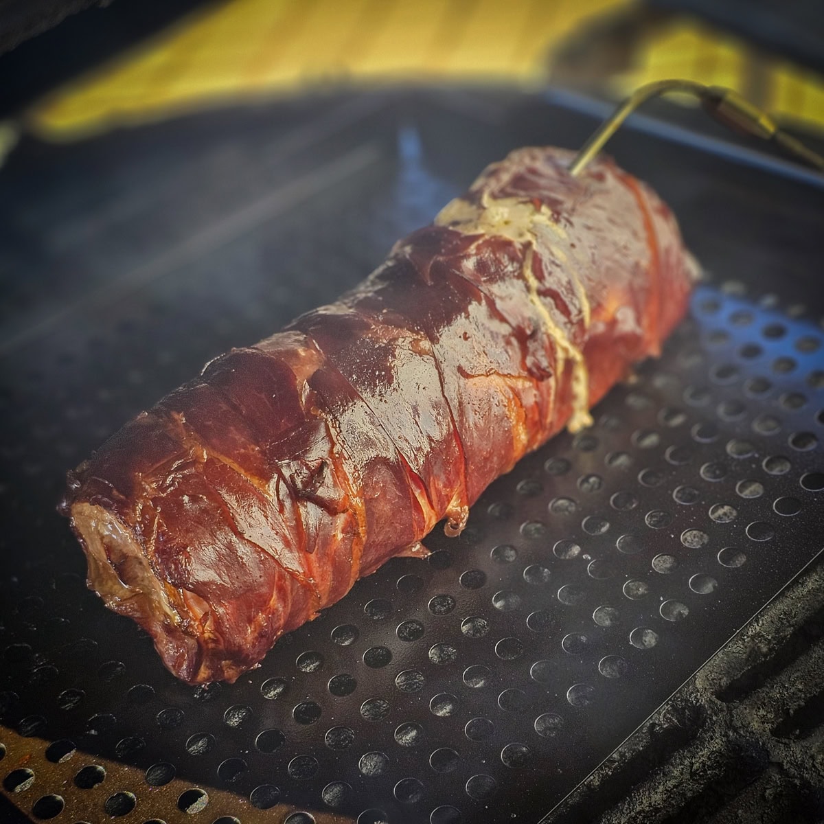 Sage stuffed pork loin wrapped in prosciutto, on a smoker.