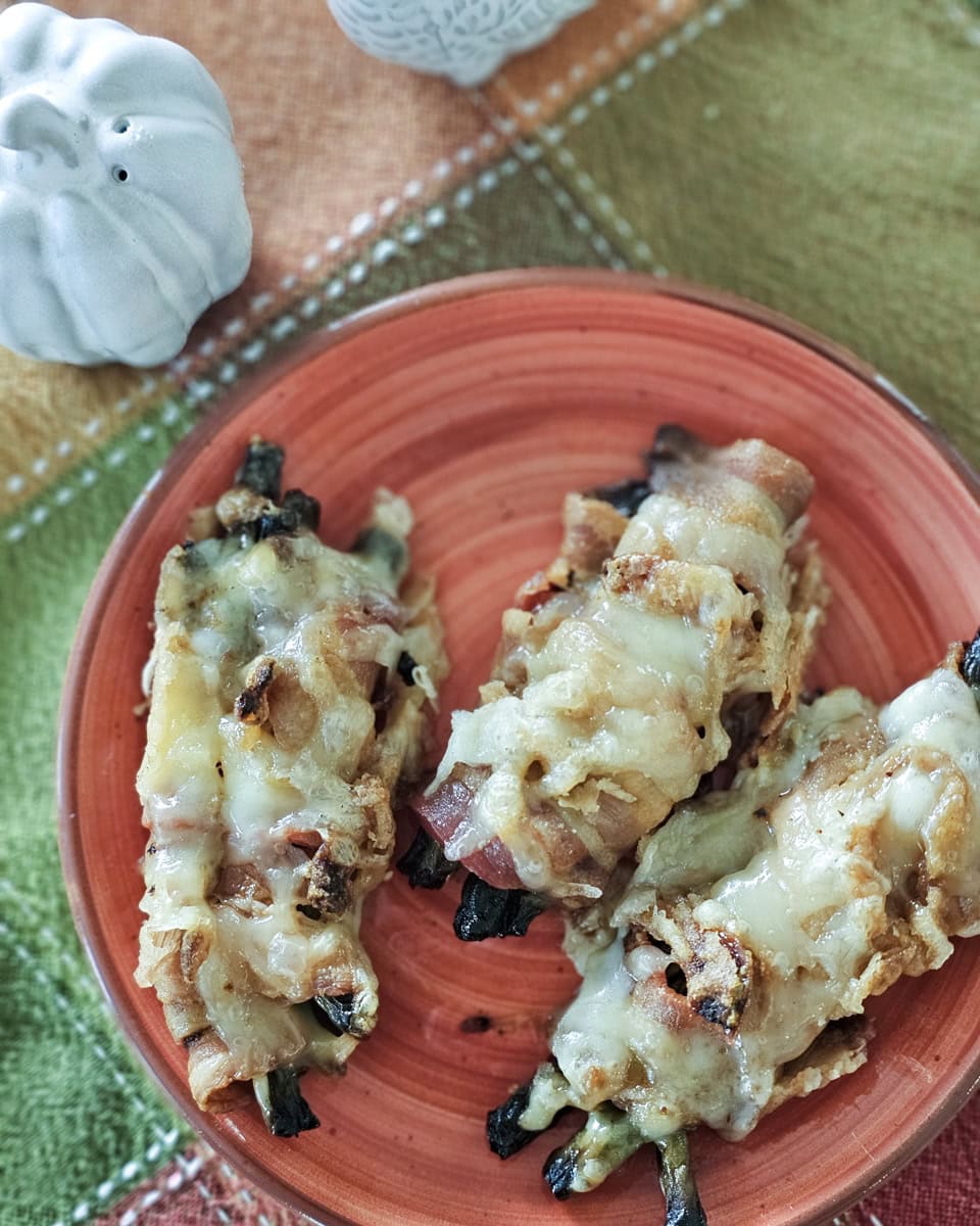 Bacon wrapped green bean bundles topped with melted cheese.