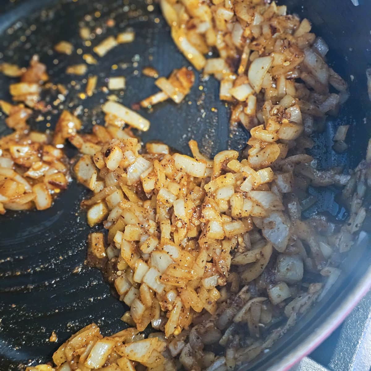 Onion cooked in a pan with spices and tomato paste.