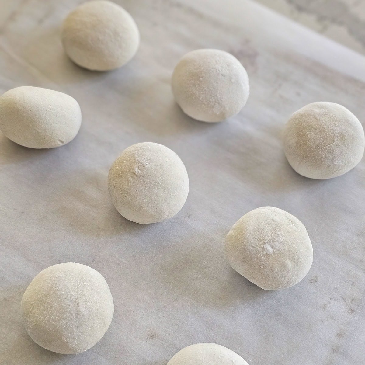 Rhodes Rolls thawing on a cookie sheet.