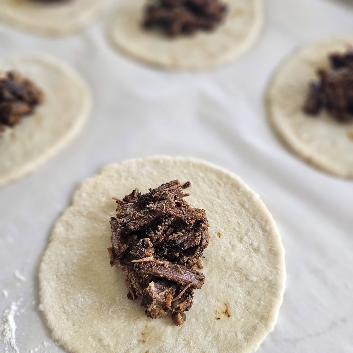 Filling kolache dough with barbecue brisket.