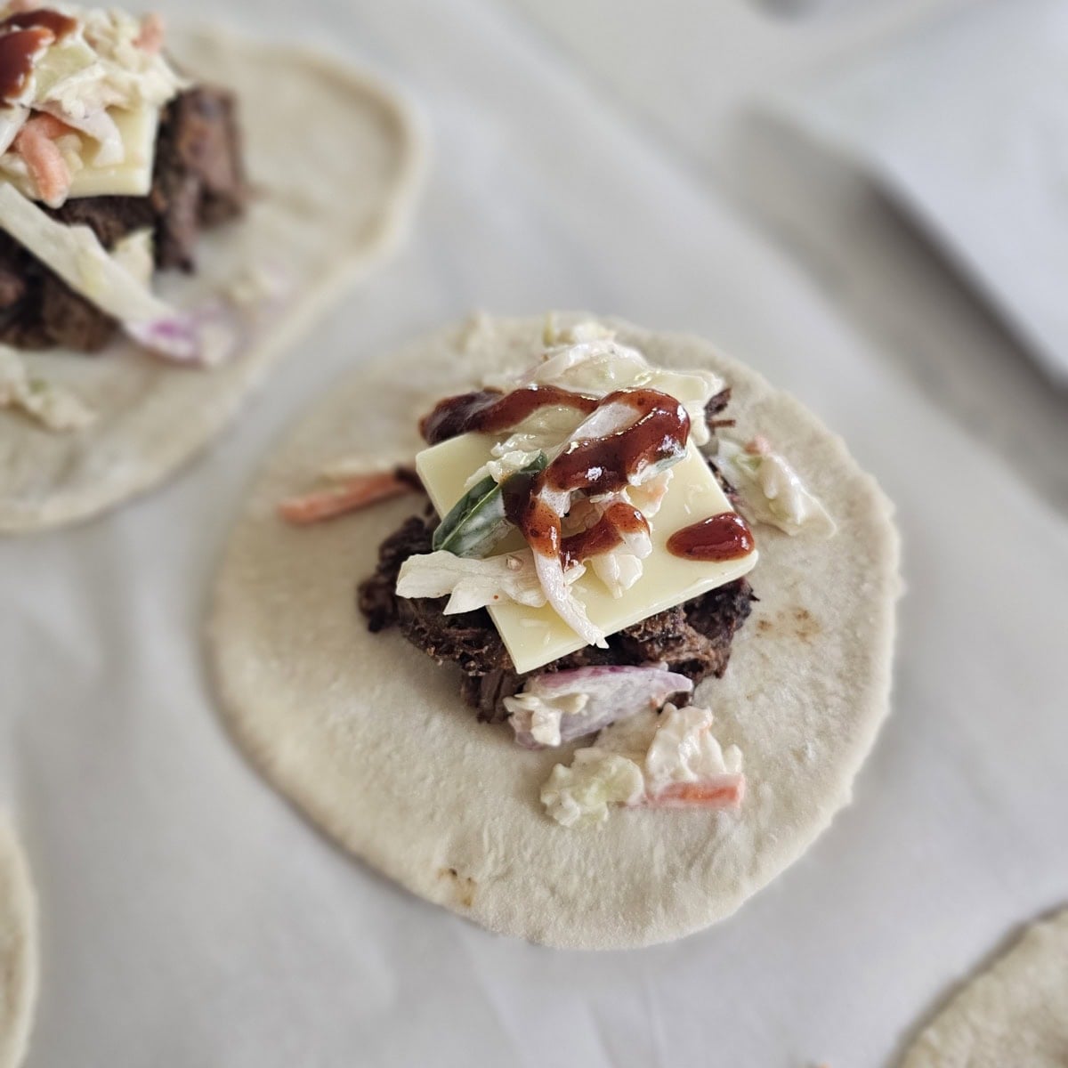 BBQ kolache filled with smoked brisket, cheese, slaw, and BBQ sauce.