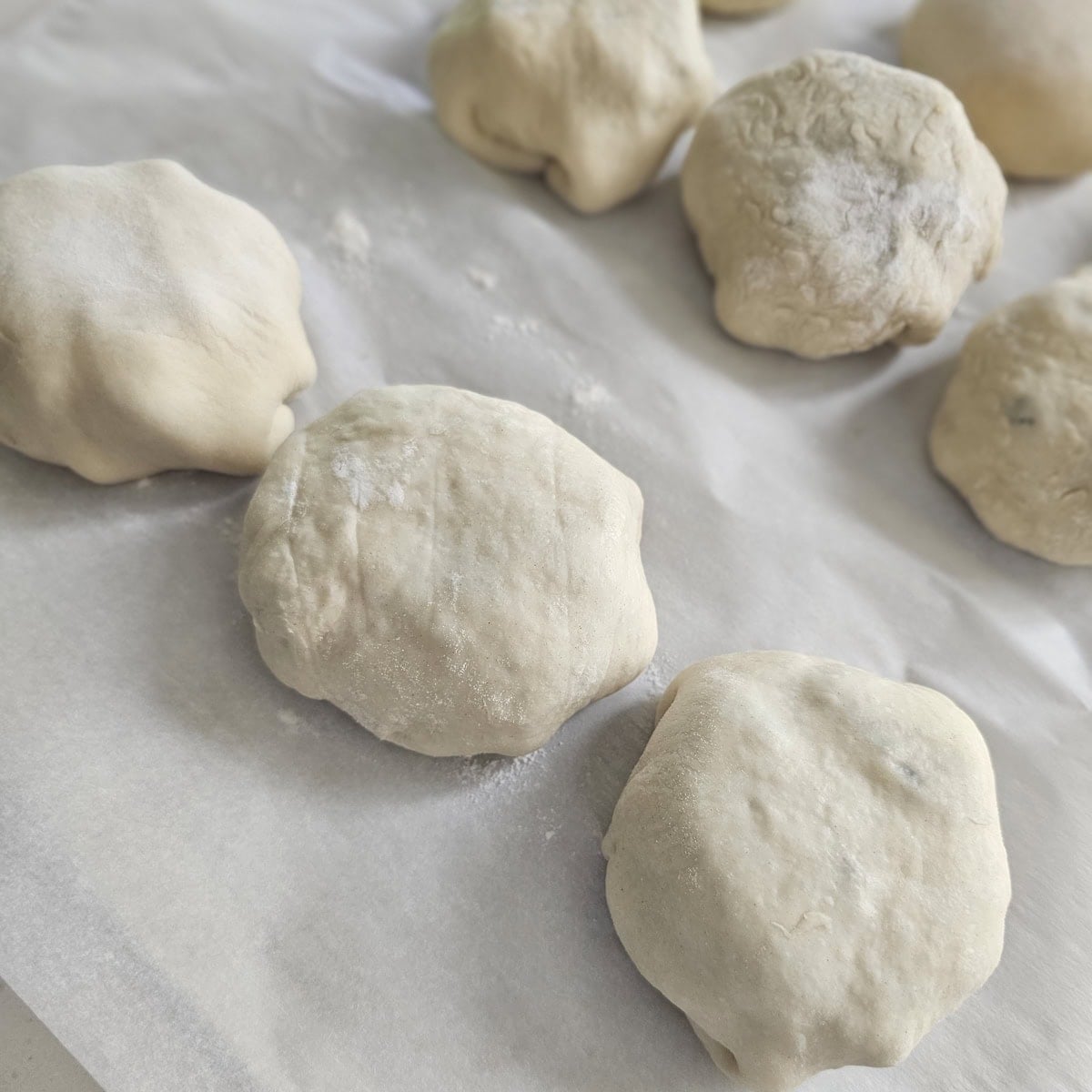 BBQ brisket kolaches rising on a cookie sheet.