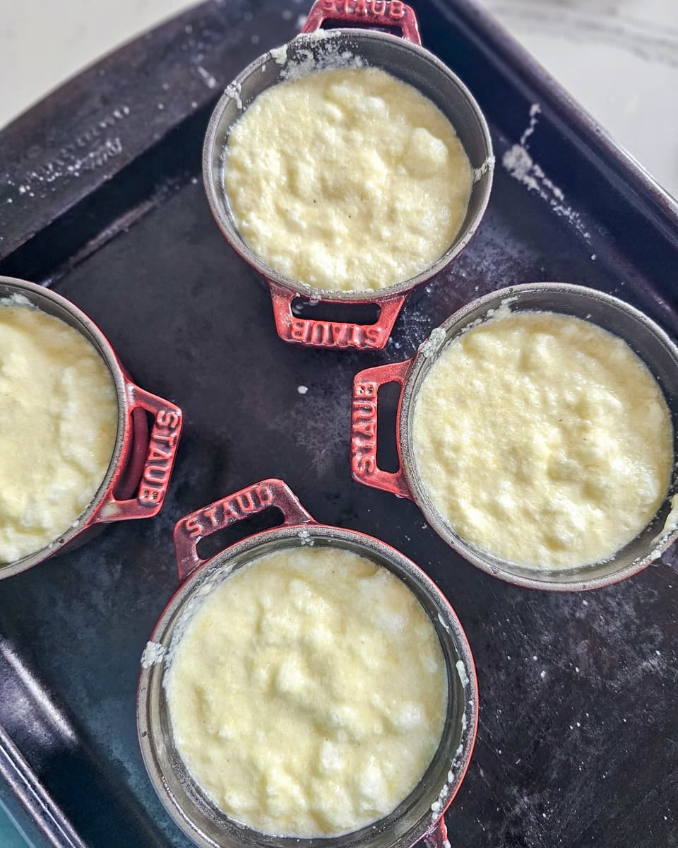 Spoon bread batter poured into individual cocottes.